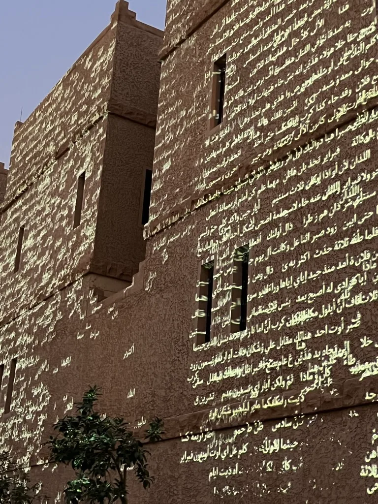 Arabic text projected across historic architecture at night